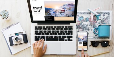 Overhead view of a laptop screen and someone planning travel