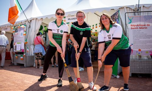 Three people holding hurls at an exhibitor tent