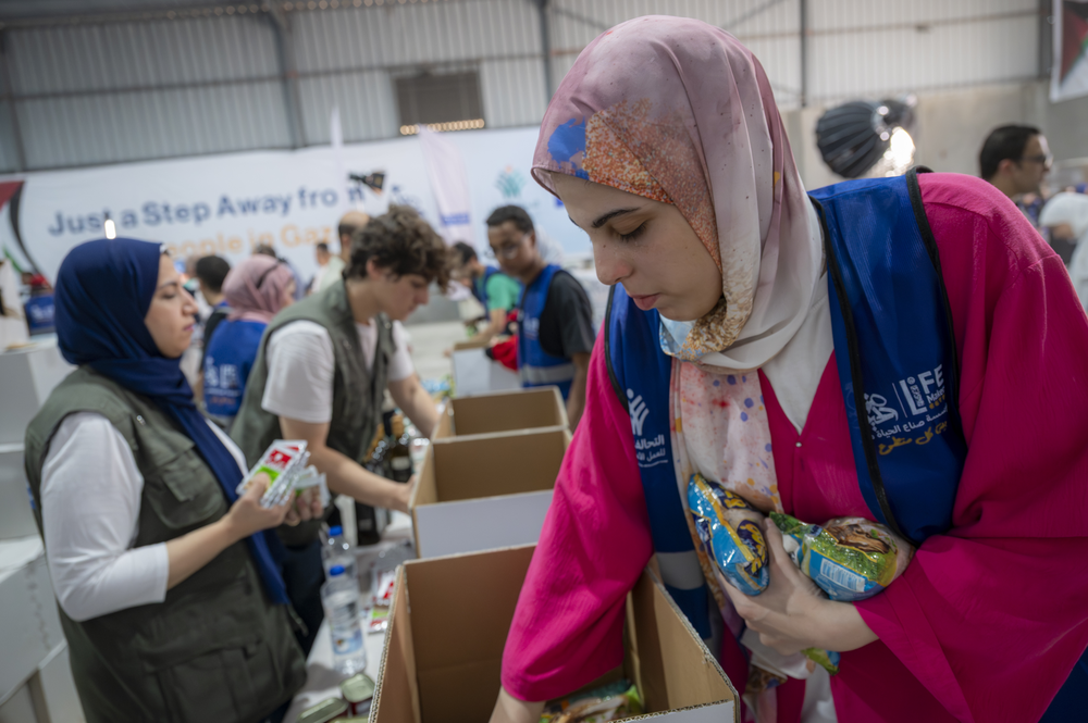 Woman with food parcels in aid warehouse